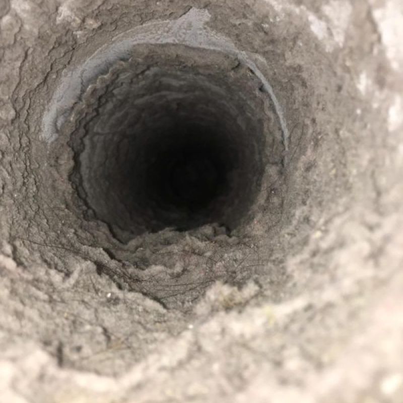 Close-up view of the inside of a dusty, lint-filled dryer vent or duct, showing significant buildup along the interior walls—an issue that can affect both heating and air conditioning efficiency in your HVAC system.