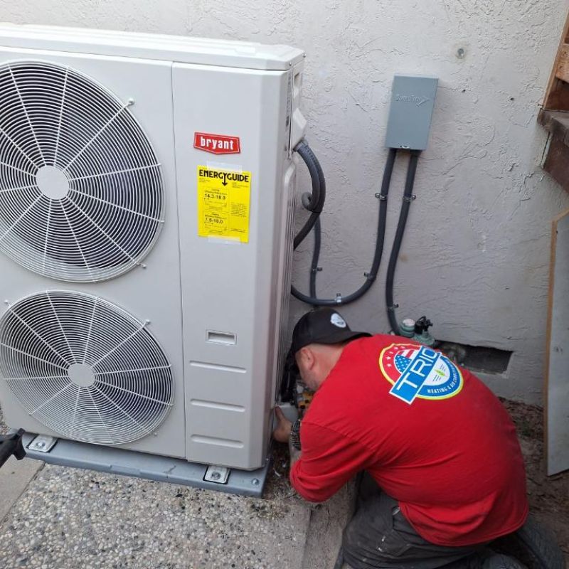 Technician installing outdoor air conditioning unit for efficient home cooling.