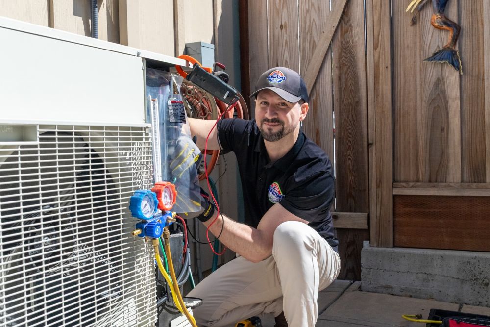 Technician repairing outdoor air conditioning unit on a sunny day.