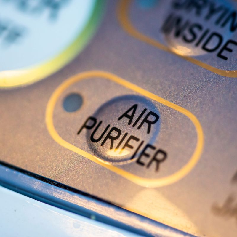 Close-up of an air purifier button on a control panel, highlighting its functionality and design.
