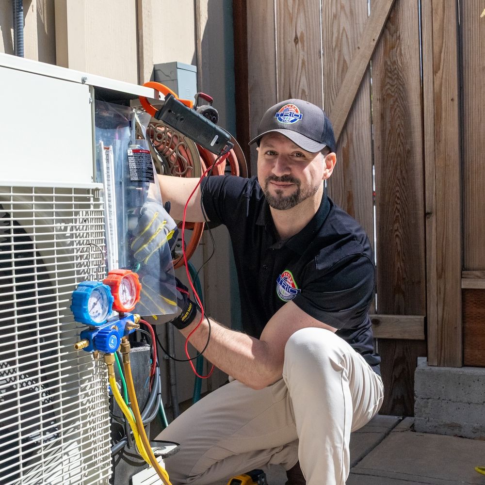 Technician repairing outdoor air conditioning unit on a sunny day.